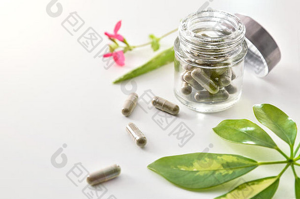 自然医学胶囊开放玻璃Jar说谎白色表格芦荟真正植物叶子自然医学概念升高视图水平
