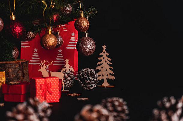 树下的红色小礼盒，黑色背景，圣诞装饰，圣诞礼物，社交媒体的圣诞图片，文本的空白空间