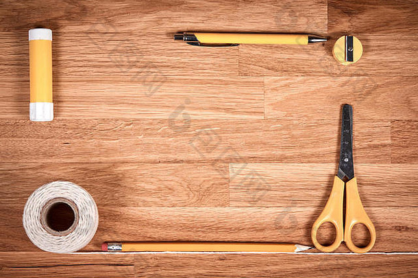 <strong>棕色</strong>木制油浸橡木桌上的绳索、细绳、铅笔、钢笔和卷笔刀