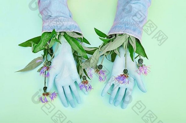 手和春天的花朵放在一张霓虹绿的<strong>护肤</strong>桌上。天然化妆品，用于手部皮肤护理、保湿。天然夏<strong>季</strong>化妆品