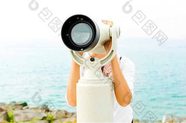 通过双筒望远镜或望远镜观看的女人