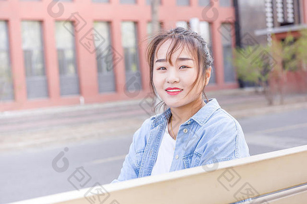 年轻的女人坐着板凳上大学