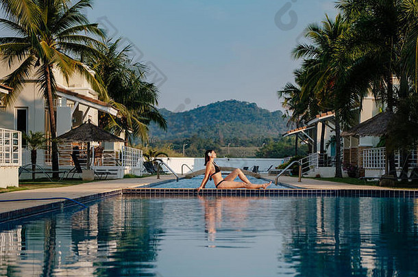 暑假在豪华酒店，女人在美丽的游泳池附近放松。<strong>美容美体</strong>中心。后视图，无面