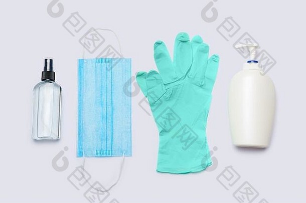 卫生物品的平面布局-浅灰色背景上的乳胶手套、口罩和洗手液