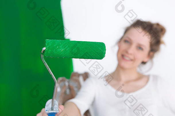 女人绘画墙绿色持有油漆辊相机