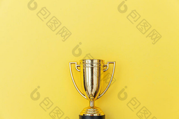简单平放设计的冠军或冠军金杯，隔离在黄色彩色背景上。胜利是比赛的第一名。胜利或成功的概念。俯视空间