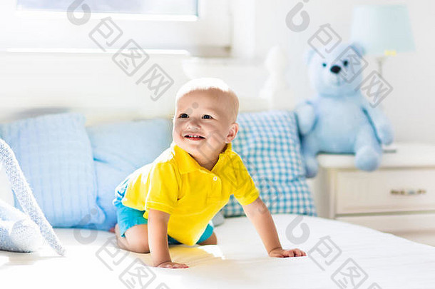婴儿玩父母床上可爱的有趣的男孩学习爬白色阳光明媚的托儿所婴儿蹒跚学步的房间室内床上用品玩具