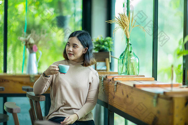 年轻的亚洲女人享受咖啡咖啡商店