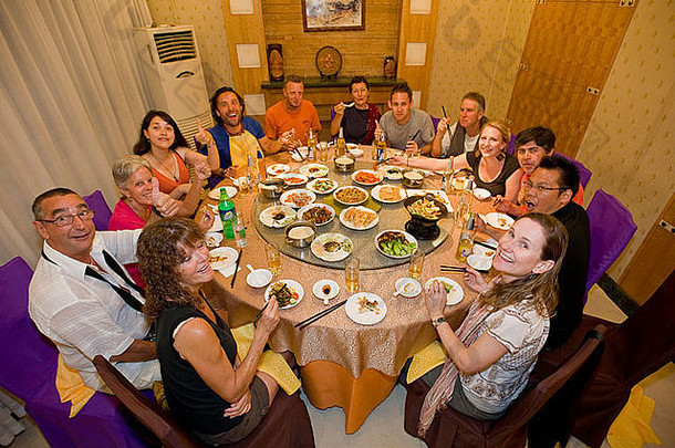 一群高加索游客在西安的一家餐厅享用传统的中餐。