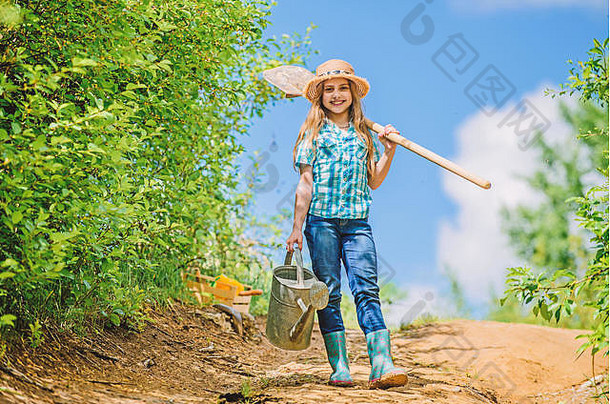 牧场上的小女孩。夏季农业。农夫小女孩。园艺工具、铲子和水壶。桑尼。家庭纽带。春天乡村边的村庄。未来的成功。土壤和肥料。