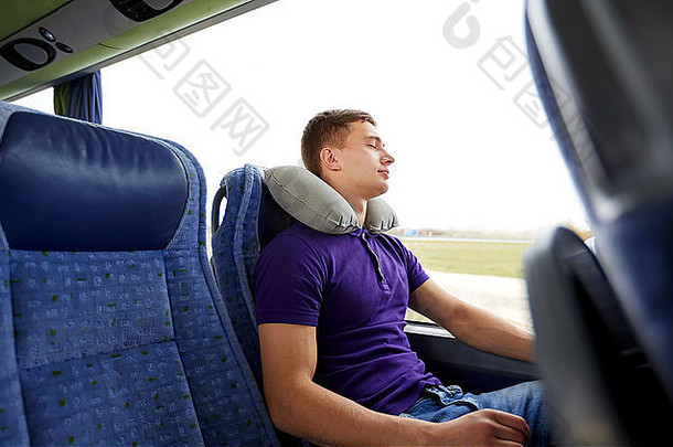 快乐的年轻人带着枕头睡在旅游巴士上