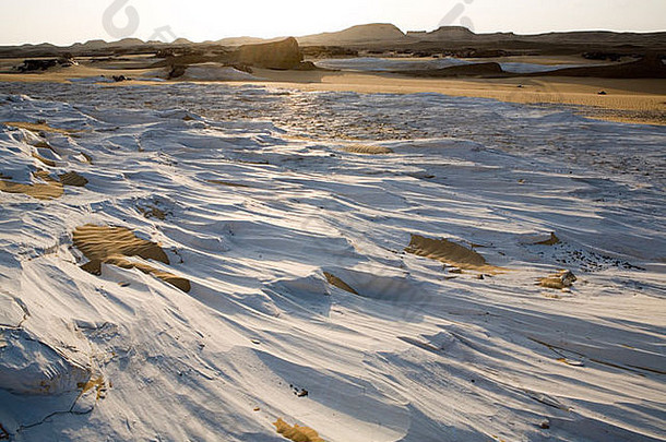 设置太阳反映风侵蚀白色石灰石形成波沙漠地板上达赫拉绿洲埃及