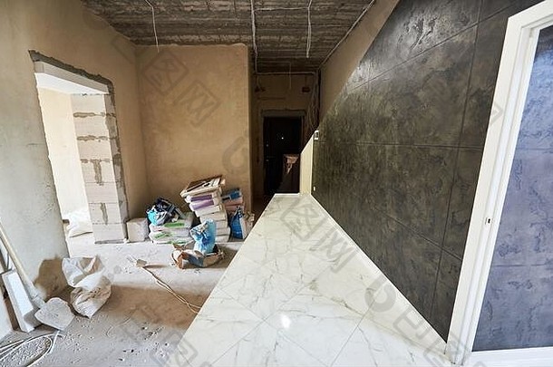 重建工程开始时脏乱肮脏的房间与新房间干净闪亮的瓷砖部分、白色地板和黑色墙壁、翻新概念