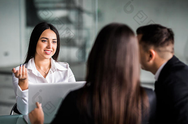 这对年轻的情侣彼此依偎在一起，看着坐在他们面前的一位女士