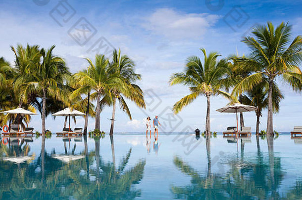 蜜月者在游泳池边散步。热带天堂岛豪华五星级度假村