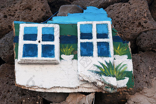 西班牙北非加那利群岛富尔特文图拉的埃尔·科蒂略：手工制作的装饰物：<strong>黑色岩石</strong>上挂着白色窗户的木板
