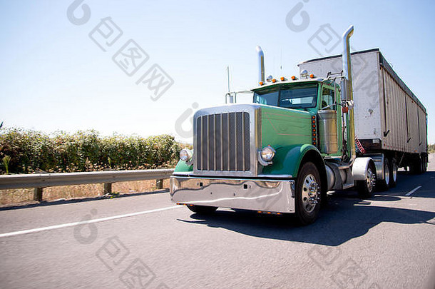 经典的美国bonneted大型绿色钻机半卡车，配有高时尚的镀铬排气管，用散装集装箱拖车运输商业货物