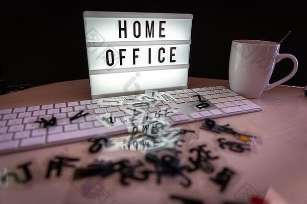 书桌上有一个写着“家庭办公室”的灯箱，前面是一个键盘
