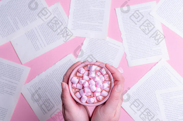女人持有手粉红色的杯热巧克力粉红色的迷你棉花糖表格完整的书页面