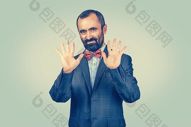 站着的留着胡子的商人展示他的手掌，显示十个手指的手势，手与绿色背景隔离。符号，肢体语言，非版本