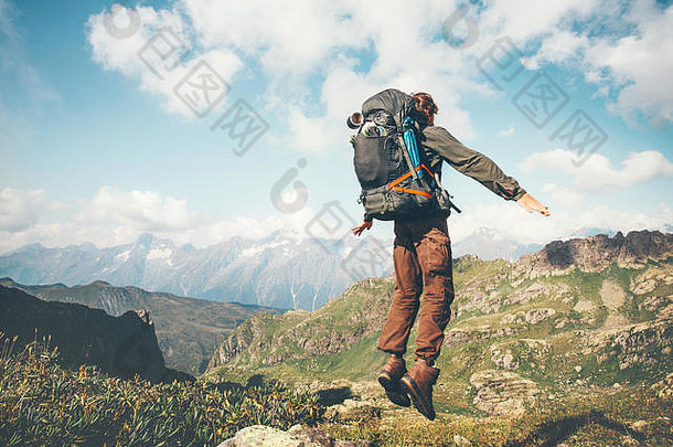 快乐男人。跳悬浮重背包山生活方式旅行情感兴奋成功概念冒险活跃的假期户外