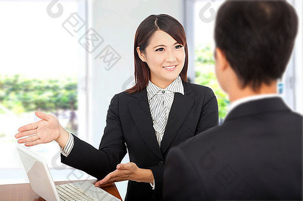 微笑的女商人在笔记本电脑前展示，并向客户解释工作计划