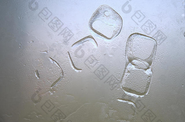 在一个装有水滴的白色玻璃上，冰块痕迹的抽象随机形状。在炎热的夏天降温-概念。