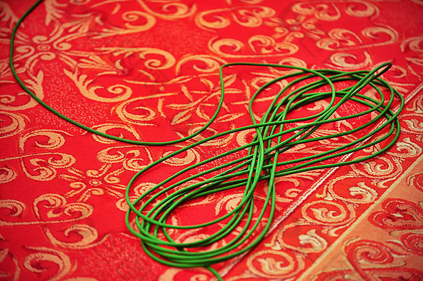 细节拍摄绿色电视电缆盘红色的地毯