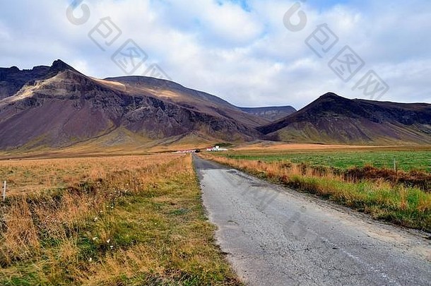 冰岛博尔格纳斯。在冰岛西部靠近博尔纳雷斯的地方，一条乡村公路提供了通往一个与世隔绝的农场的通道，农场后面的群山使它相形见绌。