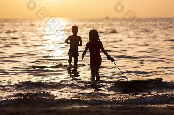 快乐孩子们玩海滩日落时间概念夏天假期友好的家庭