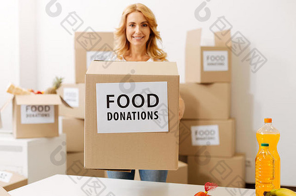 一位精力充沛、坚定的妇女手里拿着一个装满捐款的盒子