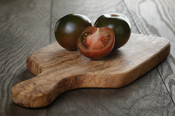 橄榄板上的成熟库马托西红柿，乡村风格