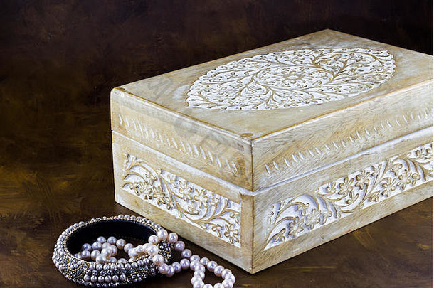 带手镯和珍珠项链的雕刻木珠宝盒