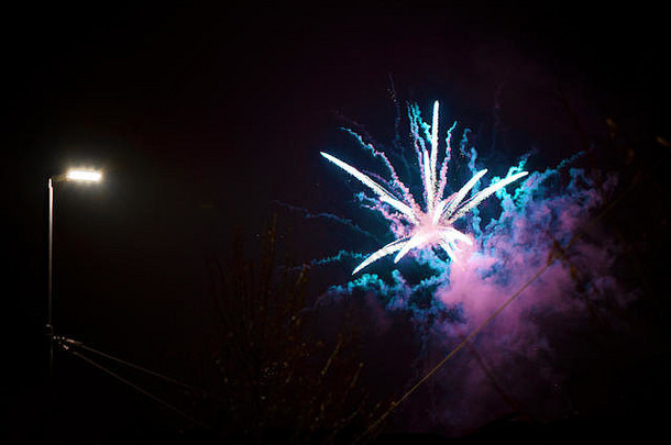 五颜六色，美丽的烟花在城市上空的夜空中绽放。新年庆典。模糊的流星