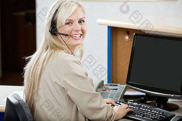 在接待处用电脑的开朗女人