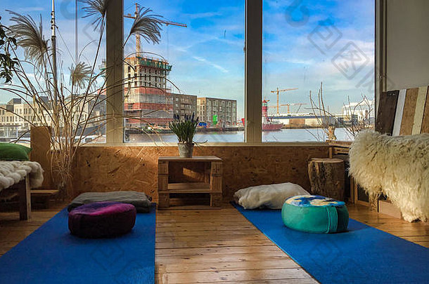 在阿姆斯特丹，在水旁边的游艇地板上冥想或瑜伽垫