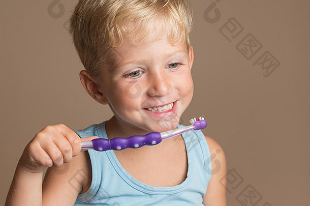 带牙刷<strong>的</strong>小，微笑快乐<strong>的</strong>小，儿童牙齿卫生和健康，棕色背景。