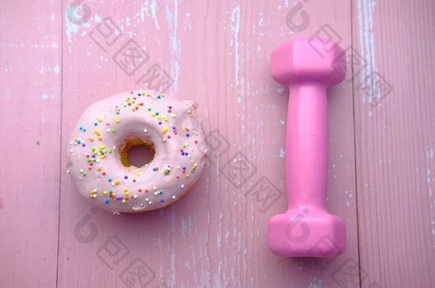 甜甜圈哑铃粉红色的背景