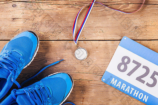木地板背景上的跑鞋、奖牌和比赛号码