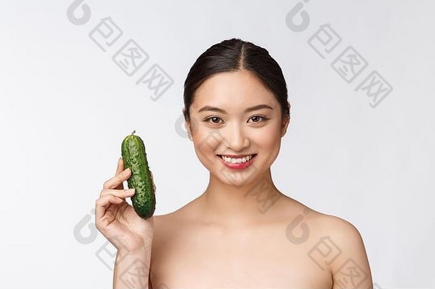 亚洲年轻的女人孤立的背景持有黄瓜