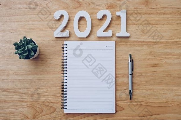 新年2021名单。带笔记本的办公桌和带盆栽的薄烤盘。