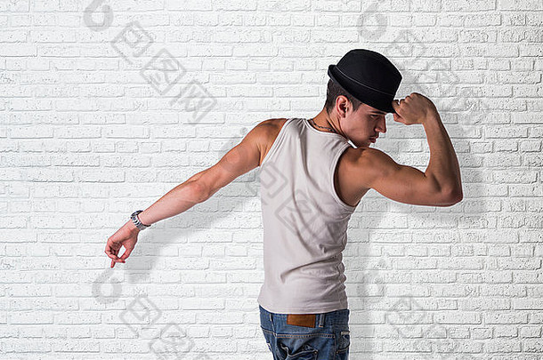 戴着帽子跳舞的时髦年轻人，靠着白砖<strong>墙</strong>