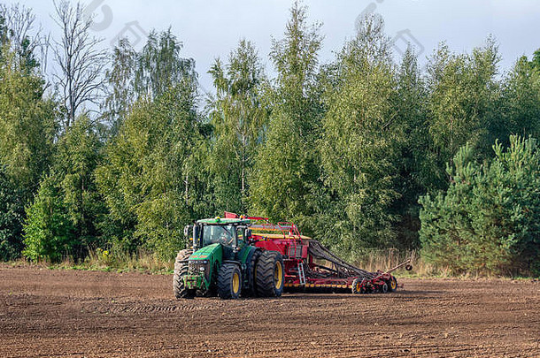 农民秋天对待字段拖拉机丰富了矿物化肥