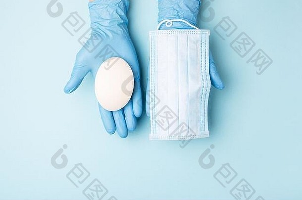 手戴手套，蓝色背景上显示肥皂和医用面罩。防止病毒感染的预防措施。