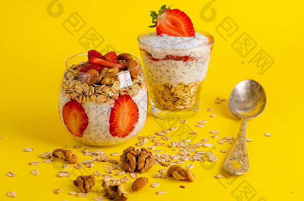 排毒健康的超级食物早餐概念传讲布丁草莓oatmeals坚果玻璃明亮的黄色的背景前面视图