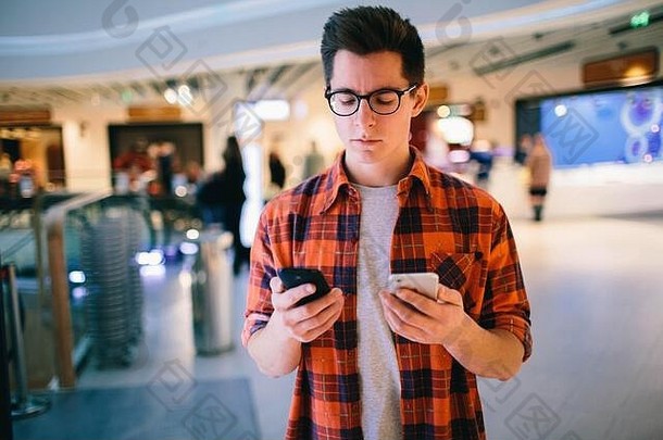 男子将智能手机放在购物中心的背景上