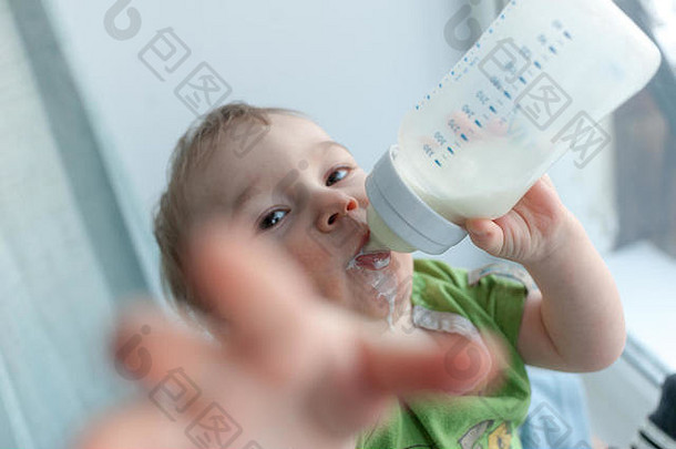 婴儿喝牛奶瓶持有甜蜜的有趣的