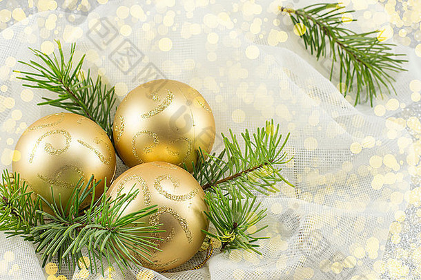 冷杉树枝上的金色圣诞装饰品