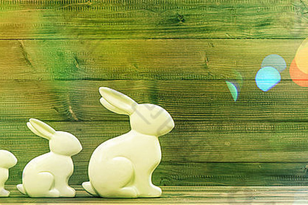 在乡村木制背景上的复活节兔子。带有漏光的复古风格色调图片