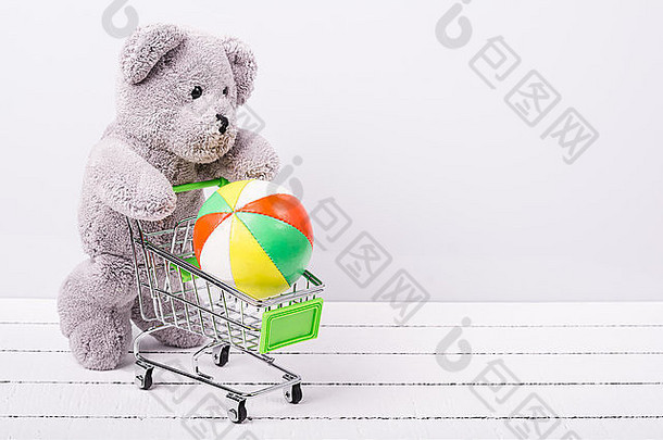 小购物车和一只泰迪熊。出售玩具或儿童幻想的概念形象